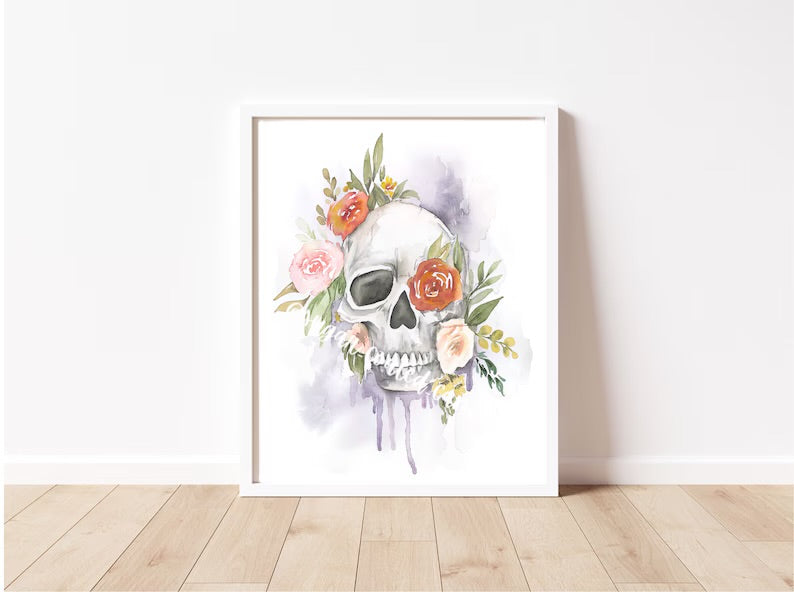 Framed artwork of a skull with floral elements on a white wall.